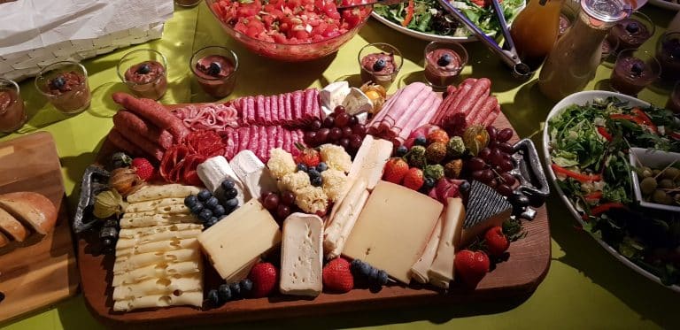 Eine große Platte mit Käse und Obst auf einem Tisch für eine Veranstaltung mit Catering.